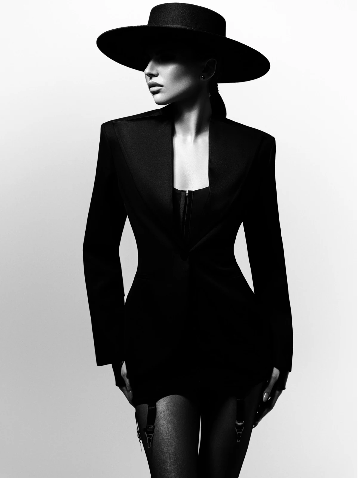 Monochrome fashion portrait in a structured black blazer and wide-brim hat
